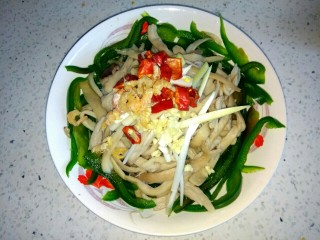 8、炝拌杏鲍菇,把青椒控水捞出放入盘中，杏鲍菇用手攥干水份放入盘中，放入葱蒜干红辣椒，加入适量海米