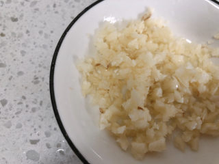 1、豆皮金针菇卷,把蒜头切成蒜末备用。