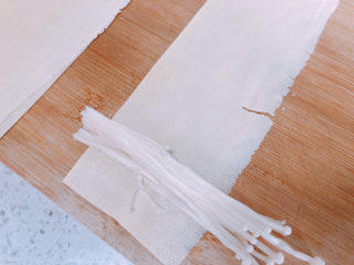 6、豆皮金针菇卷,捞起焯水过的豆皮，每张豆皮放上一撮金针菇，卷起来。