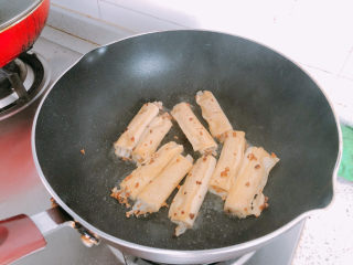 11、豆皮金针菇卷,煎好一面再翻过来煎另一面。