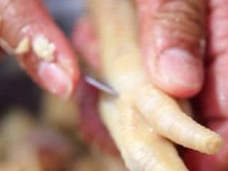 4、天生吃货秘制凤爪,脱骨:这是最费心力的环节,要准备好锋利的小刀。从鸡爪手背儿最中间的指尖向下,一直划到另一个末端,再依次划开剩下的三根手指。扒开划破的皮肉,先把手指里的关节一一拽出,再扯出来最长的那根骨头,于是一只鸡爪就只剩下干净的皮肉了。虽然说起来简单,但一只鸡爪脱骨却要花费一分钟的时间。脱骨后的鸡爪需要再过一遍凉水,一是清洗,二是可以让鸡爪剖开的皮肉更加紧实。