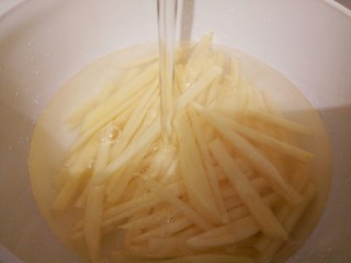 2、炝薯条,再切丝,要宽一点(炸好会缩小),放入适量清水,泡10分钟,中间可以换几次水,洗去淀粉,捞出沥干水分,这样可使土豆口感更为爽脆