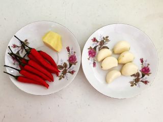 1、私房菜 密制酸辣鸡爪,把鲜姜削皮,蒜瓣和小米辣清洗干净