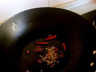 2、家常炖鱼,油锅烧热放入花椒大料干辣椒煸炒