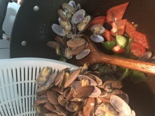 12、彩椒炒花甲,继续倒入花甲，翻炒均匀