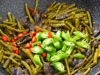 6、麻辣酸脆,又下饭又下酒,尝上一口就停不下来,下杭椒、小米椒继续翻炒。