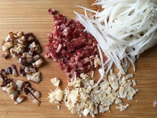 2、广式萝卜糕,食材处理：萝卜刨丝，腊肉香肠切小粒，干贝碾碎。后面一步处理萝卜丝的照片忘记拍照了，做法如下：先炒香辣肉，再锅里加萝卜丝，加适量的盐和白胡椒。