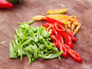 4、豆腐卷凉拌三椒,把柿子椒和红椒，黄椒用刀切成丝。