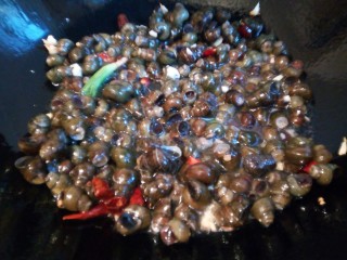 9、下酒菜【酱爆螺蛳】,倒入螺蛳转大火翻炒,淋少许料酒去腥,也可以加啤酒,都是一样的,