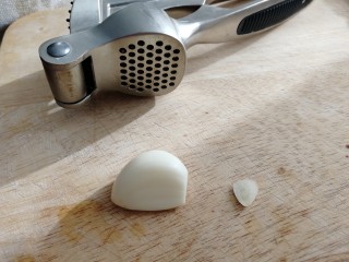 8、黄瓜拌猪耳朵,一瓣蒜去皮切去顶部。