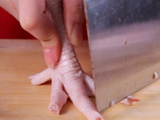 2、往鸡爪里倒入一瓶啤酒，吃起来大呼过瘾,先用刀子将鸡爪坚硬的指甲部分砍掉（以免吃多的时候影响口感）