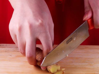 6、往鸡爪里倒入一瓶啤酒，吃起来大呼过瘾,趁着鸡爪焯水的过程，我们来将大蒜剁成末备用，生姜切片备用。（带皮也没关系因为后面出锅我们会挑出姜片）