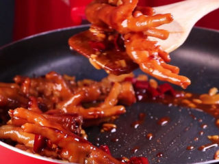 13、往鸡爪里倒入一瓶啤酒，吃起来大呼过瘾,收干汤汁的鸡爪色者看起来更加的诱人。这时就可以出锅转盘了。