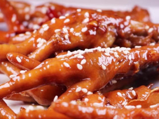 15、往鸡爪里倒入一瓶啤酒，吃起来大呼过瘾,最后再撒上一些白芝麻提香，这样一盘又香又好吃的啤酒鸡爪就做好啦，拿来当下酒菜或者当零食吃味道都非常的赞呢。