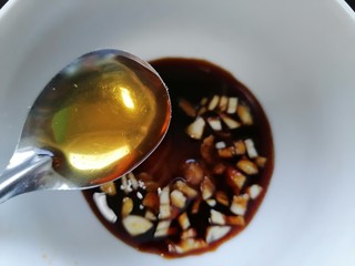 14、尖椒皮蛋,加入一勺芝麻油并将酱汁搅拌均匀