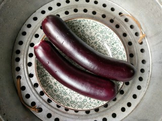 2、风味手撕茄子,将长茄子洗净去头，放进盘中，开水上锅蒸15分钟。