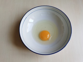 2、炸香椿鱼,碗里打入一个鸡蛋。