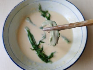 10、炸香椿鱼,将香椿一棵棵放入面糊中,蘸上一层面糊。