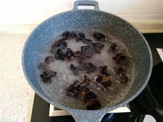 6、东北大拉皮,锅内水烧开后 倒入木耳焯水。