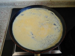 11、东北大拉皮,倒入不粘锅 摊成鸡蛋饼 鸡蛋饼定型后 翻面 关火 利用锅的余温把鸡蛋饼带熟 这样摊出来的鸡蛋饼才嫩。