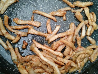 18、东北大拉皮,锅内倒入适量食用油 倒入腌制好的肉丝 快速翻炒至肉丝变色即可关火。