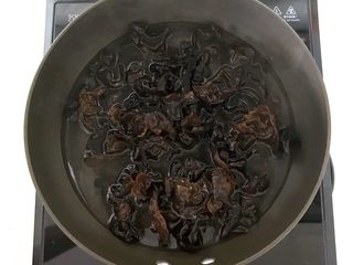 4、捞汁北极贝,锅里加入冷水，烧开后放入木耳焯水2分钟