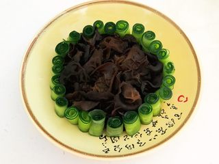 23、捞汁北极贝,在盘子中间放入木耳，用黄瓜卷把木耳围起来