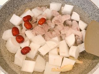 5、白萝卜排骨汤,放入水，然后放入红枣，白萝卜块，排骨盖上锅盖，大火煮开后转小火炖一个小时，出锅前放入白胡椒粉和适量盐