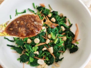 14、菠菜拌花生米,浇上调好的大蒜料汁拌匀。