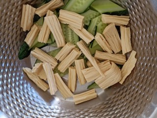 8、凉拌腐竹黄瓜,准备一个略微大一点的容器，黄瓜片和腐竹倒进容器中。