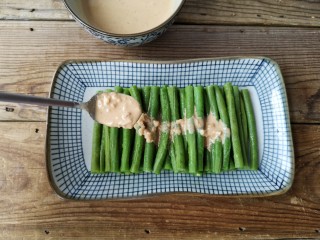 7、麻汁豆角,将豆角摆放在盘内，淋上麻汁即可。