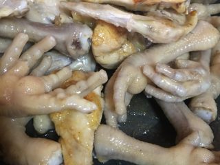 9、吮指香卤鸡爪,待糖色炒至金黄色可以把鸡爪放入锅中快速翻炒.