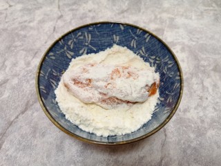 5、香酥炸鸡翅,先将腌好的鸡翅放入玉米淀粉里面,表面粘上一层玉米淀粉。