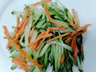 11、黄瓜凉拌金针菇,将腌制好的黄瓜丝挤掉水分和胡萝卜放在一起