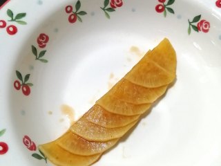 17、糖醋白萝卜,取切开半片的萝卜片，叠好，然后，由下往上卷起来，卷成一朵花的形状