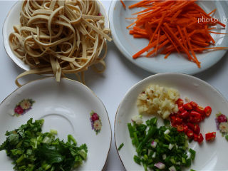 2、凉拌豆腐丝,.将豆腐皮毛切成细丝，胡萝卜切成细丝，香菜，小葱，小米辣，大蒜切细。