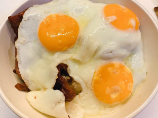 14、三眼荷包蛋叉烧饭,最后依次在米饭上铺上：叉烧、煎好的荷包蛋，再淋上调好的料汁就可以拌饭吃了