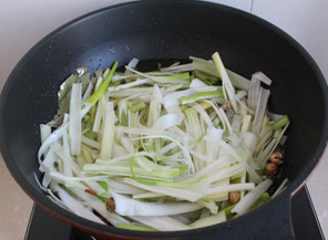 8、#夏天的味道# 如何做东北人餐桌上的明星凉菜——东北大拌菜 ,待香料炸出香味，放入大葱姜丝香菜根等。