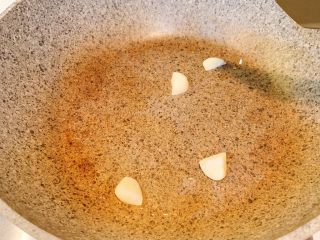 4、扁豆炒腊肠,冷锅热油，放入蒜翻炒出味