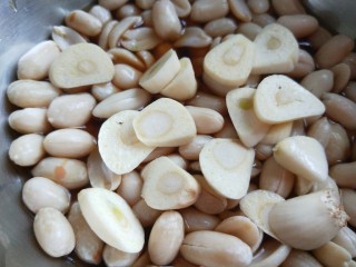 10、醋泡花生米,蒜去皮切片放入花生里。