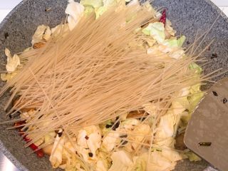 9、卷心菜炒五花肉粉丝,加入红薯粉翻炒均匀，需要加入3杯水焖软红薯粉