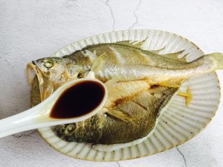 13、广式清蒸黄鱼,倒掉汤汁夹出葱段不要，再淋入一勺蒸鱼豉油