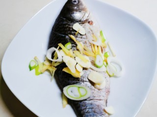 7、香煎鲫鱼,葱姜蒜放到鱼身上