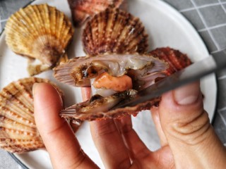 5、蒜蓉粉丝蒸扇贝,再用小刀将扇贝肉与壳分离。