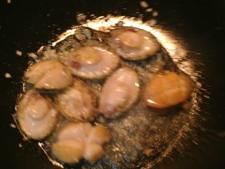 4、红烧鲍鱼,放入鲍鱼翻炒，八分熟时放入料酒、酱油、糖、醋、盐，一直翻炒到汁儿基本收干