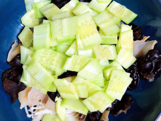 8、黄瓜凉拌金针菇,黄瓜切片儿放入盘中。