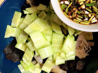 13、黄瓜凉拌金针菇,将拌料倒入盘中。