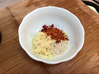 8、蒜蓉茄子,取一个小碗，放入蒜蓉，一汤匙熟白芝麻，一小袋辣椒粉