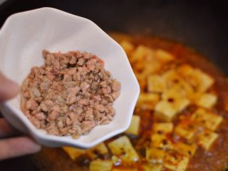 19、正宗地道的麻婆豆腐,煮开后放入牛肉末、生抽、黑胡椒粉和白糖少许。调小火，盖上锅盖。（中间可以打开锅盖，用铲子轻推防止粘锅）