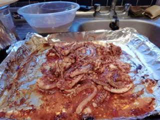 12、洛氏新煮义--烧烤黑椒猪肉VS烧烤孜然鱿鱼,然后撒上辣椒粉和孜然粉，再放入烤箱，烤2分钟